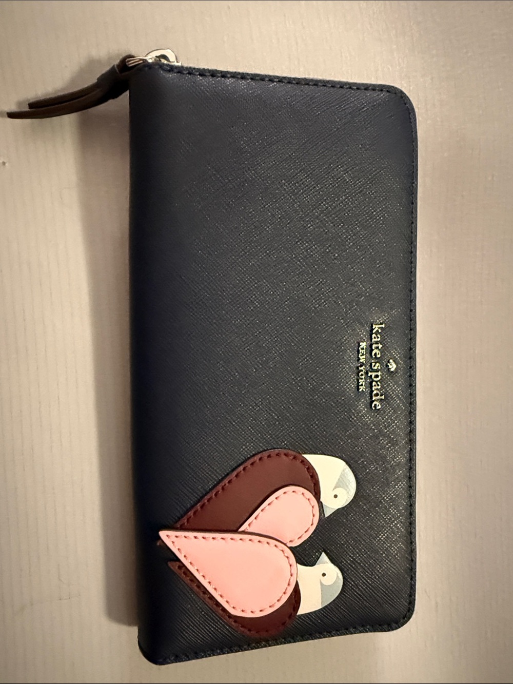 kate spade navy leather zip-around wallet with pink and burgundy bird appliqué